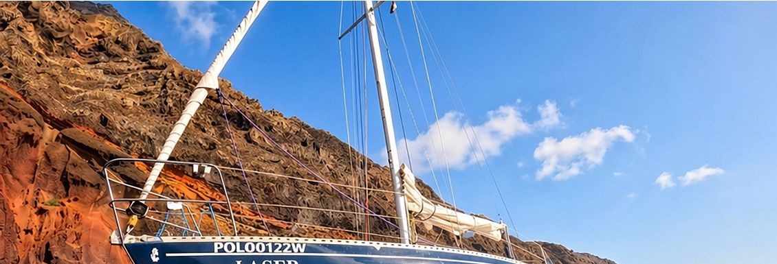 LAZER, a classic sailing yacht, anchored beneath Madeira's volcanic cliffs